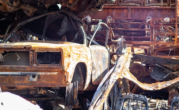 A lot of rusty burnt cars in Irpen, after being shot by the Russian military. Russia's war against Ukraine. Cemetery of destroyed cars of civilians who tried to evacuate from the war zone