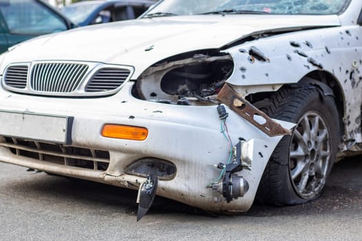 A car destroyed by shrapnel from a rocket that exploded nearby. Irpensky automobile cemetery. Consequences of the invasion of the Russian army in Ukraine. Destroyed civilian vehicle
