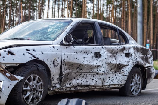 Shot, damaged cars during the war in Ukraine. The vehicle of civilians affected by the hands of the Russian military. Shrapnel and bullet holes in the body of the car. War of Russia against Ukraine
