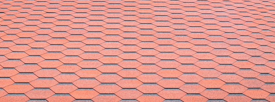 New roof with red shingles. Tiles on the roof of the house. Use to advertise roof fabrication and maintenance. Spotted texture. Affordable roofing. Banner with copy space