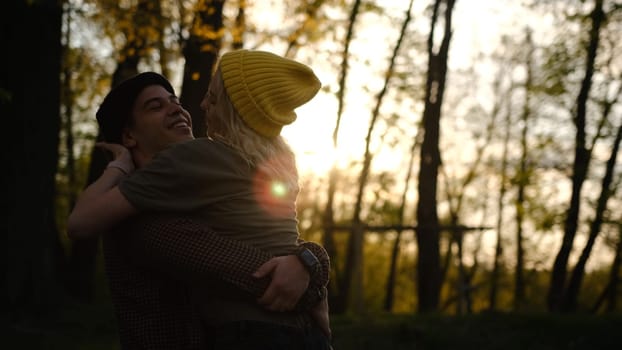 man and woman at sunset. A romantic date and love on nature of loving happy couple. Dancing and fooling couple in forest at sunset.