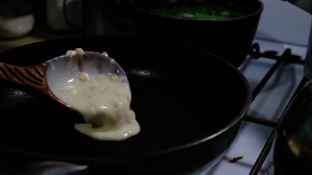 Filling a pan with pancake dough. Cooking on gas-cooker. Pancakes with holes. Pancake week. Russian tradition.. 4K 400mb s
