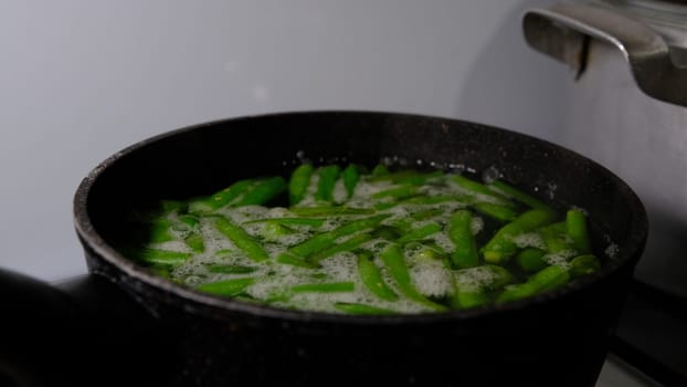 Close-up on boiling the green beans in a pot with boiling water and vapour 4K 400mb s