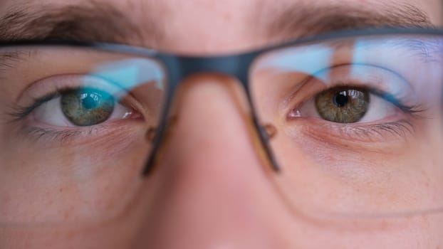 Close up of man's face with glasses. Boy opening his beautiful green eyes. European young male model with green eyes looking at camera. extreme close-up, 4K.