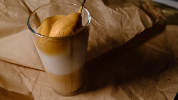 Beautiful composition - hot coffe latte cappucino in a transparent glass. Mixing by spoon 4K 400mb s
