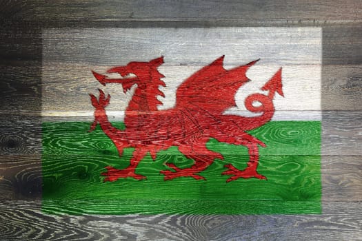 A Wales flag on rustic old wood surface background