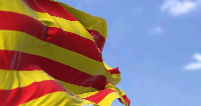 Catalan flag waving in the wind on a clear day. Catalonia is an autonomous community of Spain, designated as a nationality by its Statute of Autonomy