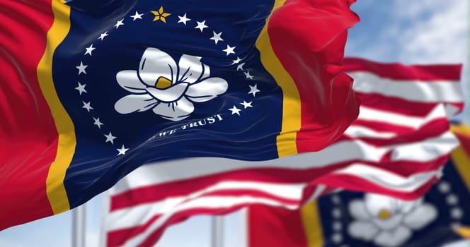 The Mississippi state flag waving along with the national flag of the United States of America. Mississippi is a state in the Southeastern region of the United States. Democracy and independence.