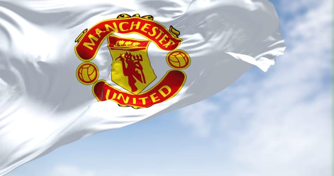Manchester, UK, May 2022: The flag of Manchester United waving in the wind on a clear day. Manchester United is a professional football club based in the Old Trafford area of Manchester, England