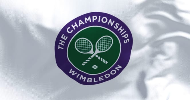 London, UK, April 2022: Close up of The Championships Wimbledon flag waving in the wind. Wimbledon Championships is a major tennis tournament scheduled in late June each year