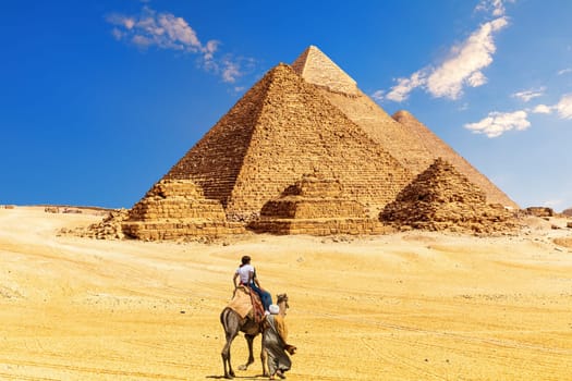 The Great Pyramid complex and bedouin with tourists in the Egypt desert, Giza.