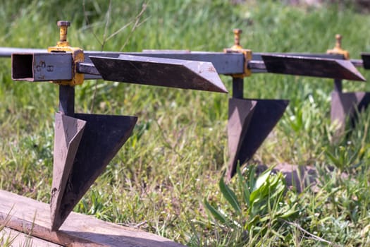 Agricultural manual metal plow on the field. Plowing the land before sowing. Close-up. Inventory for plowing potatoes in the countryside. A plow is a tool for plowing dense soil, raising virgin soil