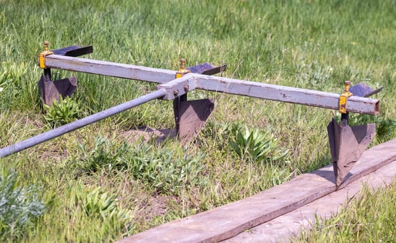 Agricultural manual metal plow on the field. Plowing the land before sowing. Close-up. Inventory for plowing potatoes in the countryside. A plow is a tool for plowing dense soil, raising virgin soil