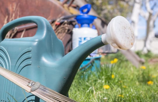 Blue plastic pot for watering in the garden. Can water. Watering can for flowers on the street, in the garden or garden on a warm summer sunny day