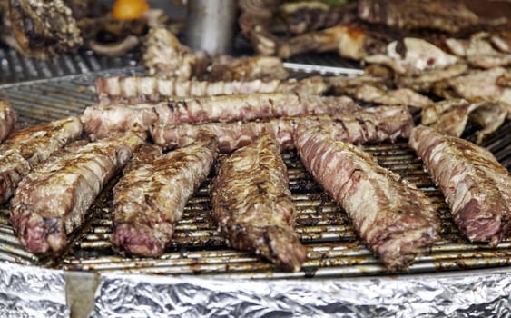 Detail of meat roasted on a charcoal grill, party and celebration