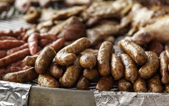 Detail of sausage meat roasted on the charcoal grill, unhealthy food
