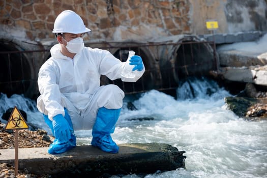 Ecologist sampling water from river with test tube glass and have white smoke, Biologist collects sample waste water from industrial of toxic chemicals, scientist environmentalist, problem environment