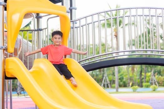 Asian child smiling playing on slider bar toy outdoor playground, happy preschool little kid having funny while playing on the playground equipment in the daytime in summer, Little boy climbing