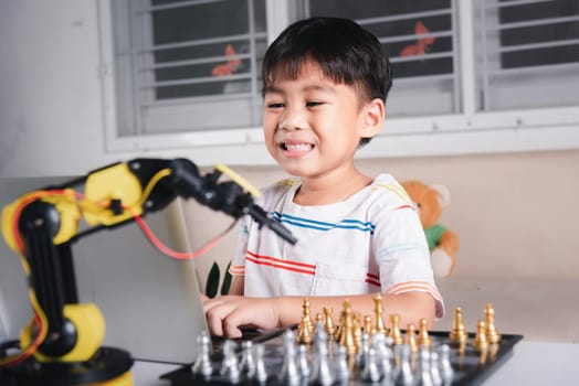 Asian little boy programming code to robot machine arm on laptop for play chess, STEM education E-learning, Funny children learning getting lesson control robot arm, Technology science education