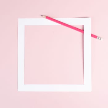 Pencil on a pink paper background, white frame with copy space for text, minimalism, creative and business concept, pastel colored