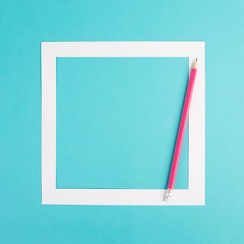 Pencils on a blue paper background, white frame with copy space for text, minimalism, creative and business concept, pastel colored