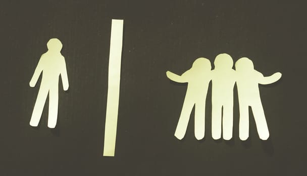 Paper man standing Isolated from group. Feel Left out and alone. Social isolation and Rejection concepts.