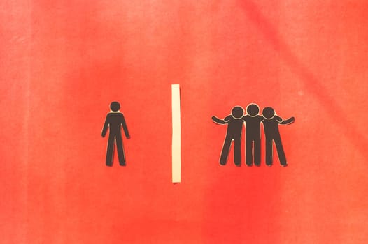 Paper man standing Isolated from group. Feel Left out and alone. Social isolation and Rejection concepts.