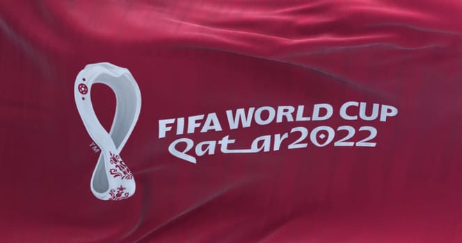 Doha, Qatar, October 2021: Flag with the 2022 Fifa World Cup logo flapping in the wind. The event is scheduled in Qatar from 21 November to 18 December 2022