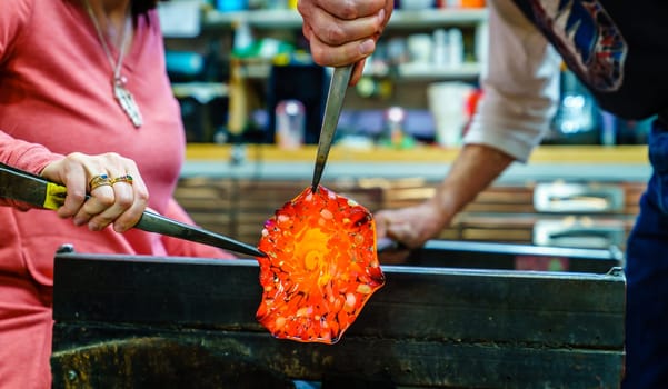 Making a glass flower in a glassblowing workshop