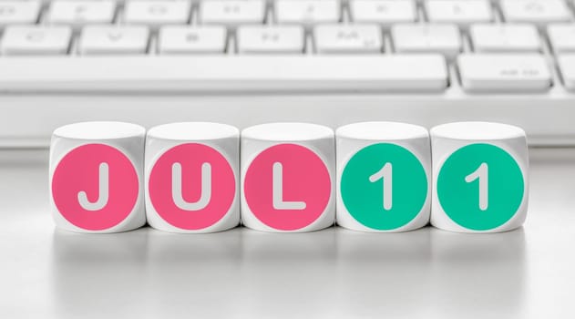 Letter dice in front of a keyboard - July 11