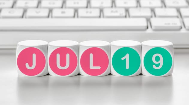 Letter dice in front of a keyboard - July 19