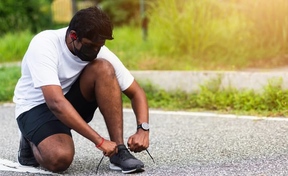 Close up Asian sport runner black man wear watch sitting he trying shoelace running shoes getting ready for jogging and run outdoor street health park with copy space, healthy exercise workout concept