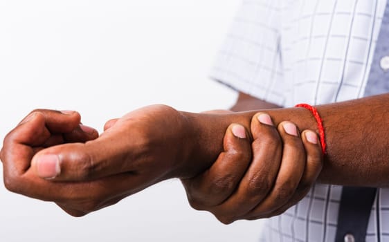 Closeup hand Asian black man holds his wrist hand injury, feeling pain, studio shot isolated on white background. Health care and medical office syndrome concept