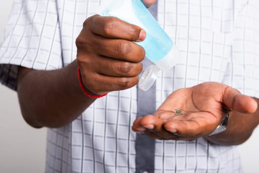 Closeup Asian black man wearing protective face mask  use sanitizer gel face clean his hand, hygiene prevention COVID-19 virus or coronavirus protection concept isolated on white background