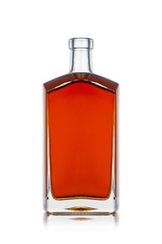 front view closeup of square modern shape cognac brandy bottle with no label isolated and amber liquid on white background with reflection