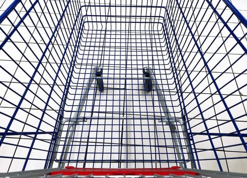 top view closeup of empty metallic shopping cart in supermarket