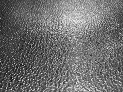 front view closeup of stainless steel plate metal flooring with embossed metallic pattern and shallow depth of field