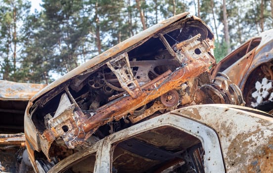 A lot of rusty burnt cars in Irpen, after being shot by the Russian military. Russia's war against Ukraine. Cemetery of destroyed cars of civilians who tried to evacuate from the war zone