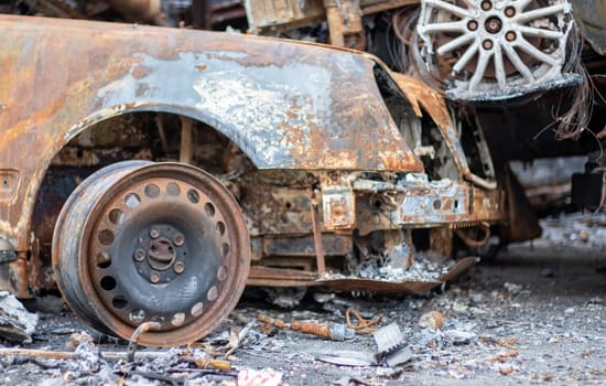A view of burnt-out cars after rocket attacks by the Russian military. War of Russia against Ukraine. Civil vehicle after the fire. Cemetery of cars in the city of Irpin. Rusty pile of metal