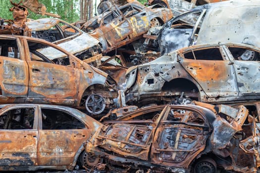 A lot of rusty burnt cars in Irpen, after being shot by the Russian military. Russia's war against Ukraine. Cemetery of destroyed cars of civilians who tried to evacuate from the war zone