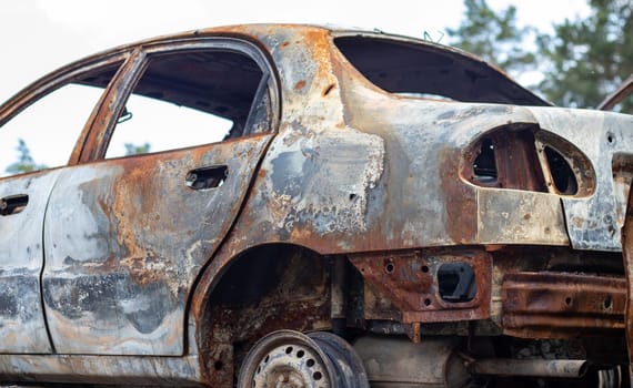A view of burnt-out cars after rocket attacks by the Russian military. War of Russia against Ukraine. Civil vehicle after the fire. Cemetery of cars in the city of Irpin. Rusty pile of metal