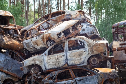 Russian invasion of Ukraine in 2022, destroyed and burned cars. Cars were beaten with shrapnel and burned. Irpensky automobile cemetery. The consequences of the war in a peaceful city near Kyiv