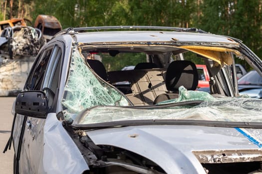Dump of shot and burned civilian cars by Russian invaders in Ukraine. The remains of cars that were shot and destroyed by shell fragments. War of Russia against Ukraine. Car graveyard