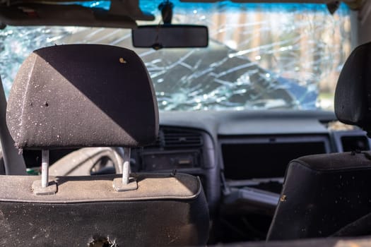 Damaged car window after an accident. Broken windshield as a result of an accident, inside view. Cabin interior details, view from the cab. Safe movement. Broken windshield. Glass crack and damage