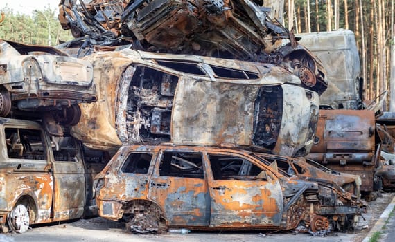 A lot of rusty burnt cars in Irpen, after being shot by the Russian military. Russia's war against Ukraine. Cemetery of destroyed cars of civilians who tried to evacuate from the war zone