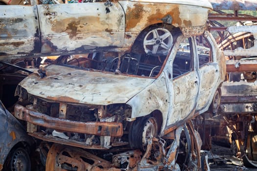 Russian invasion of Ukraine in 2022, destroyed and burned cars. Cars were beaten with shrapnel and burned. Irpensky automobile cemetery. The consequences of the war in a peaceful city near Kyiv