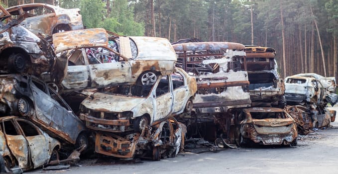 Rusty burnt cars destroyed by rocket explosions. War in Ukraine. Destroyed vehicles of civilians who were leaving were evacuated from the combat zone from Bucha and Irpin. Car graveyard