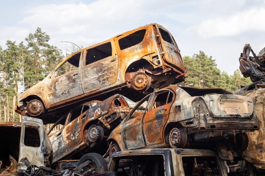 A lot of rusty burnt cars in Irpen, after being shot by the Russian military. Russia's war against Ukraine. Cemetery of destroyed cars of civilians who tried to evacuate from the war zone