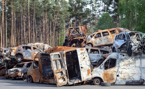 A lot of rusty burnt cars in Irpen, after being shot by the Russian military. Russia's war against Ukraine. Cemetery of destroyed cars of civilians who tried to evacuate from the war zone