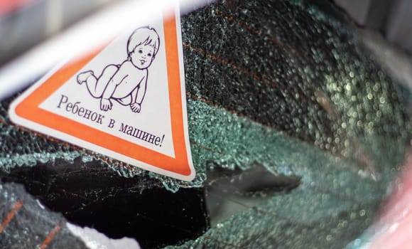 Warning sign on a car window. Translation: Child in the car. War of Russia against Ukraine. A car of civilians shot by the Russian military during the evacuation of women and children